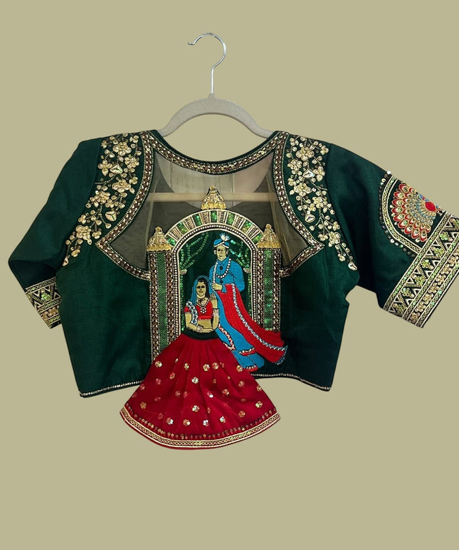 House Of Indian Wedding Attire deep green blouse with gold embroidery, sequins, and royal couple motif on sheer back panel.