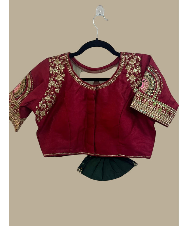 House Of Indian Wedding Attire maroon silk-like blouse with gold embroidery and matching dark green skirt.