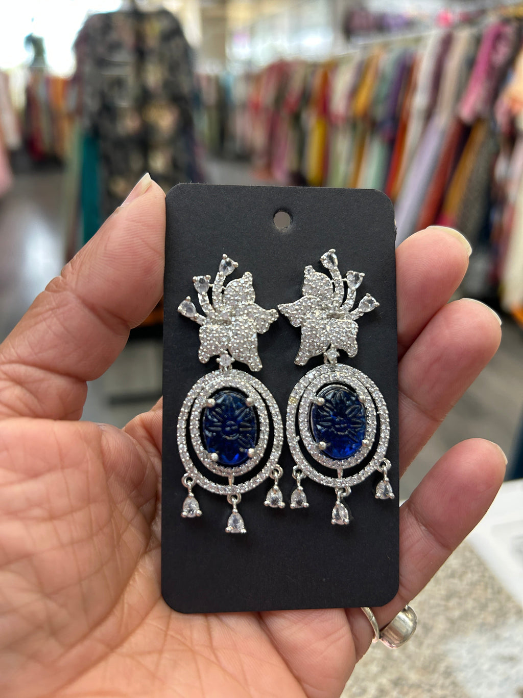 Kurti Connection USA oval blue gemstone dangle earrings with cubic zirconia halo and floral top.