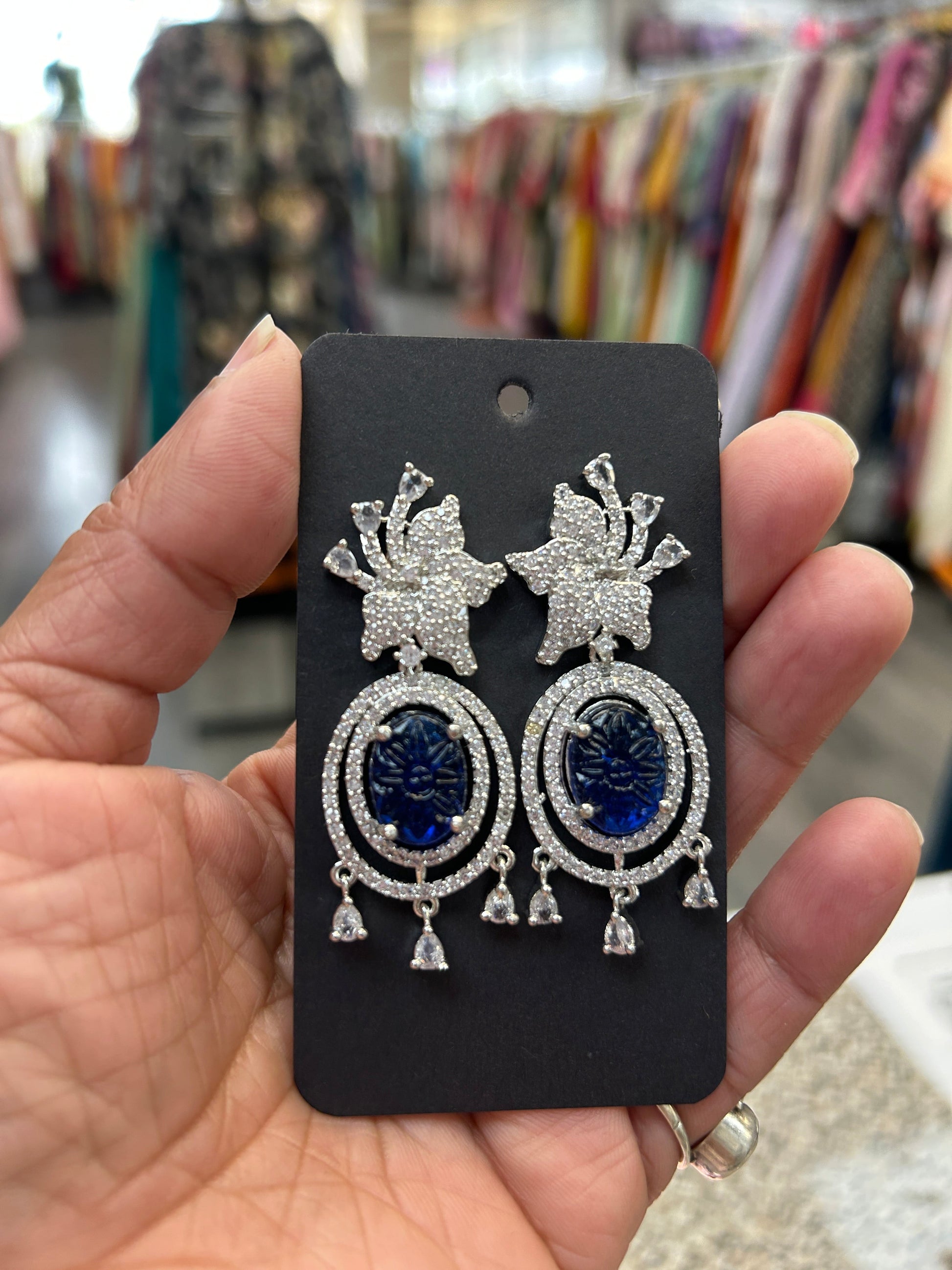Kurti Connection USA oval blue gemstone dangle earrings with cubic zirconia halo and floral top.