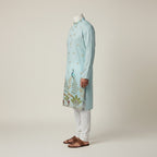 Kurti Connection USA light blue silk kurta set with intricate peacock embroidery and white pajama.