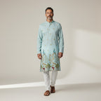 Kurti Connection USA light blue silk kurta set with intricate peacock embroidery and gold accents, paired with white pajama.