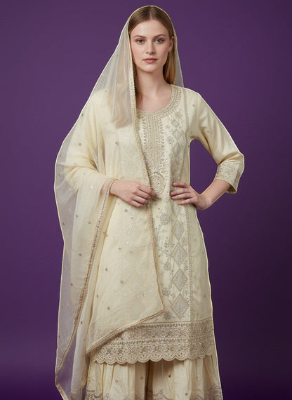 Kurti Connection USA cream silk blend kurti sharara set with silver embroidery and sequin dupatta.