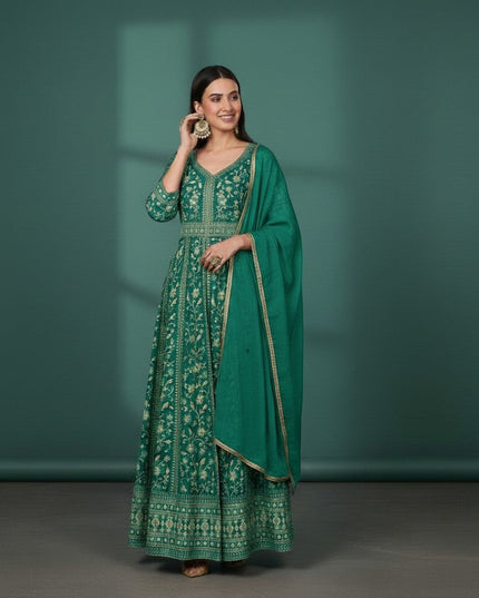 Kurti Connection USA emerald green Anarkali suit with gold embroidery and dupatta. Model wears large gold earrings.