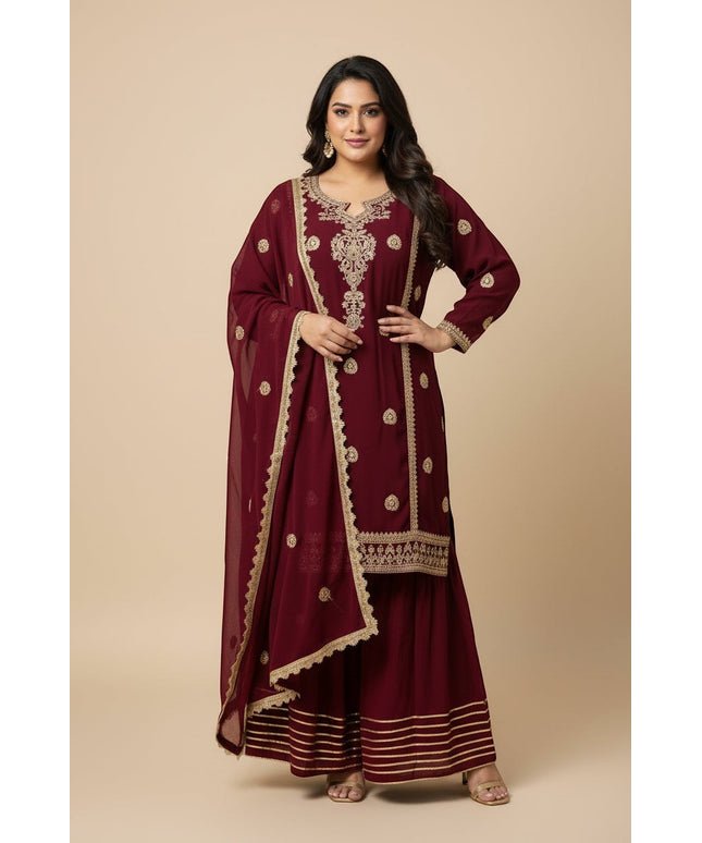 Model wearing a Kurti Connection USA maroon embroidered kurti and flared sharara set with a matching dupatta.
