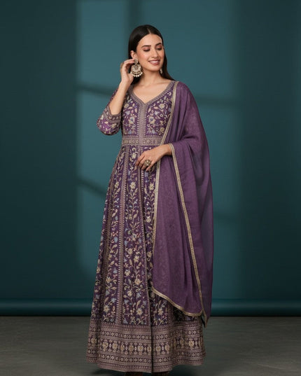 Kurti Connection USA purple embroidered Anarkali suit with all-over print and matching dupatta. Model wears statement earrings.