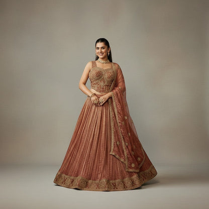 Kurti Connection USA embroidered lehenga set in warm rust with gold detailing. Sleeveless blouse and flowing pleated skirt.